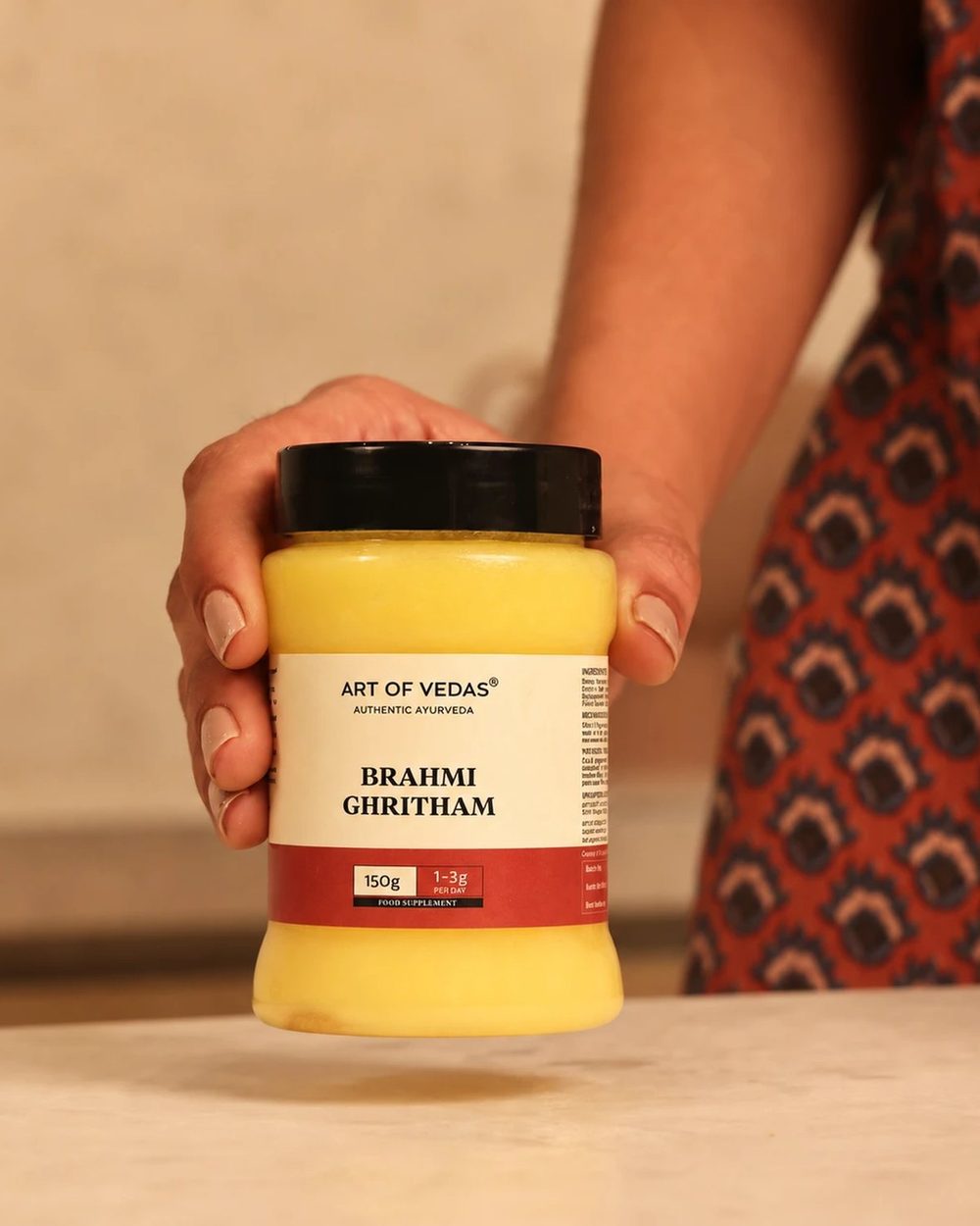 Brahmi Ghritham Art of Vedas nel suo barattolo di PET per uso alimentare, con il coperchio chiuso e l'etichetta rivolta in avanti